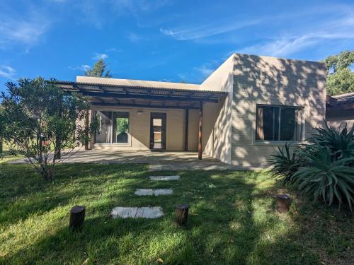 a house with a grass yard in front of it at Portal Del Campo in Piriápolis