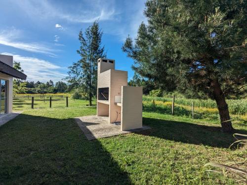 a refrigerator in a yard next to a tree at Portal Del Campo in Piriápolis