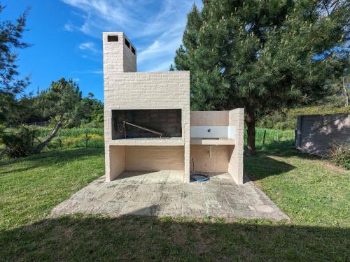 a brick fireplace with a computer on it in a field at Portal Del Campo in Piriápolis