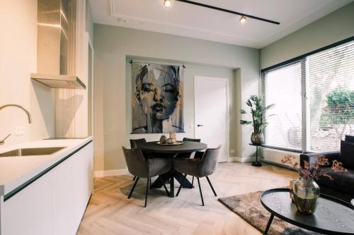 uma cozinha e sala de jantar com mesa e cadeiras em Luxurious Apartment With Garden Hendrik's em Tilburg