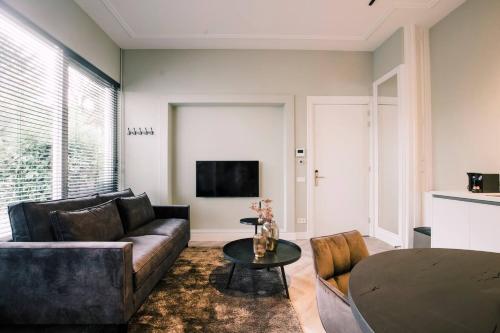 a living room with a couch and a table at Garden View City center Villa Tilburg Hendrik in Tilburg