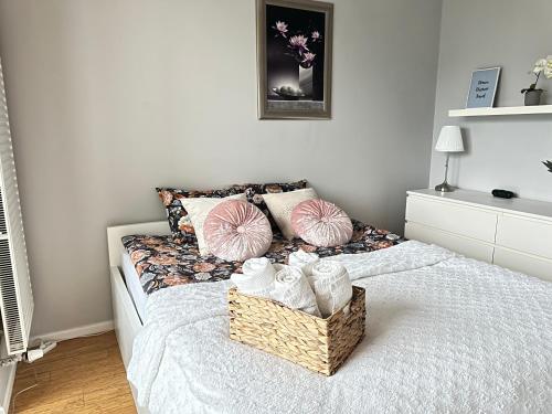 a bedroom with a bed with a basket of towels at CityHome Platinum Towers in Warsaw