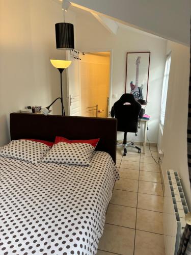 une chambre avec un lit, un bureau et une chaise dans l'établissement LA PETITE MAISON, à Le Perray-en-Yvelines