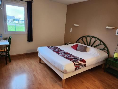 a bedroom with a bed and a table and a window at Relais De La Grange in Nort-sur-Erdre