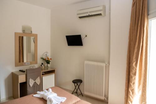 a bedroom with a bed and a desk and a mirror at Kronos Hotel in Heraklio Town