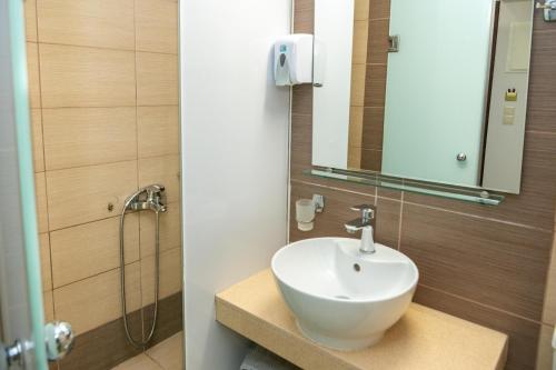 a bathroom with a sink and a shower at Kronos Hotel in Heraklio Town