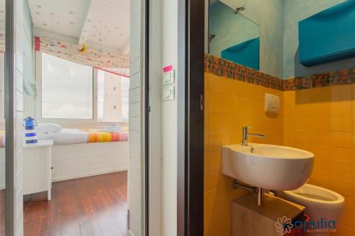 a bathroom with a sink and a bedroom at La Casa Sul Faro by Apulia Accommodation in Bari