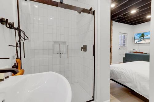 a bathroom with a glass shower with a bed at Housepitality - The Reichstag Suite - Modern in Columbus