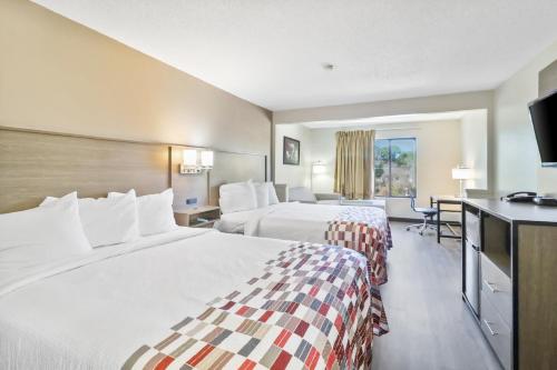 um quarto de hotel com duas camas e uma televisão de ecrã plano em Red Roof Inn & Suites Fayetteville-Fort Bragg em Fayetteville