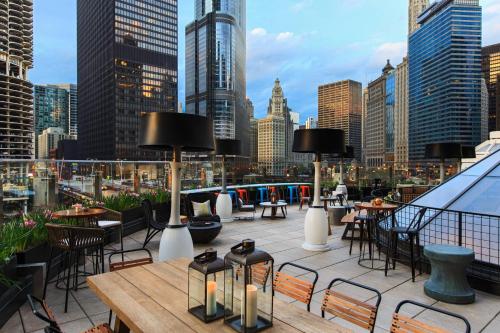 eine Dachterrasse mit Tischen und Stühlen und einer Skyline der Stadt in der Unterkunft Renaissance Chicago Downtown Hotel in Chicago