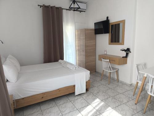 a bedroom with a bed and a table and chairs at Galini Apartments in Balíon