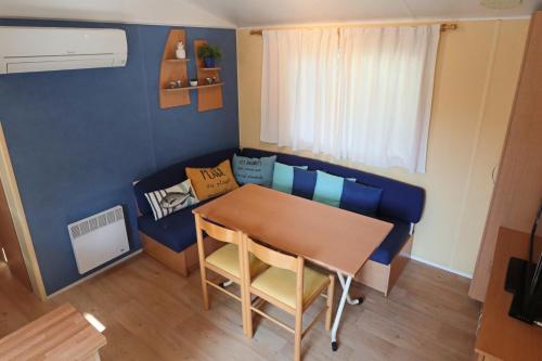 a small room with a table and a couch at Mobilhome LesPins YourHostHelper in Hyères