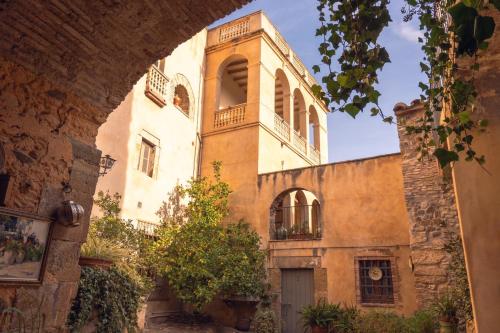 an old building with a balcony on top of it at Mas Gran de Cruïlles - Mas Rural - Hotel & Events in Cruïlles