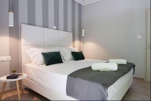 una camera da letto con un grande letto bianco con due cuscini di Koukaki Urban and Cozy Apartment ad Atene