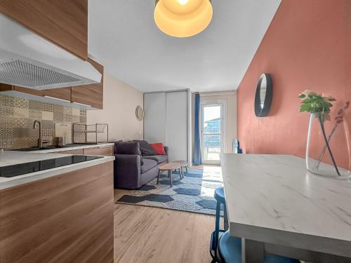a kitchen and living room with a table and a couch at Studio Lumineux au Cœur de Toulouse in Toulouse