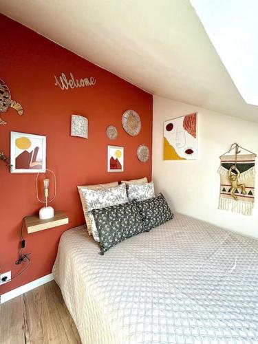 a bedroom with a bed and a red wall at Le TyTerracotta de juju, en plein cœur de la ville in Saint-Brieuc