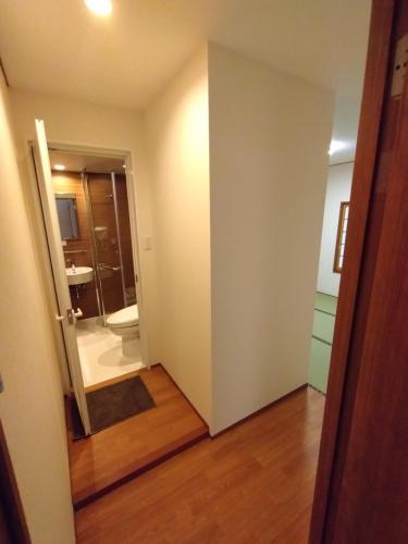 a room with a bathroom with a shower and a door at 政義の宿 