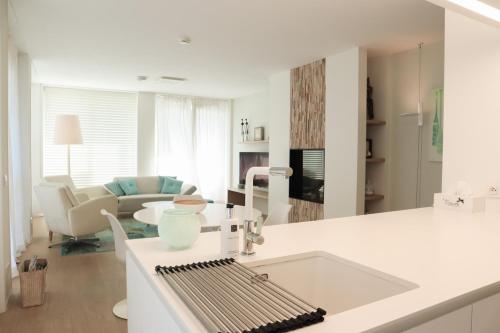 a kitchen and living room with a white counter top at Badhuis Dunes, Boulevard de Wielingen 2 in Cadzand