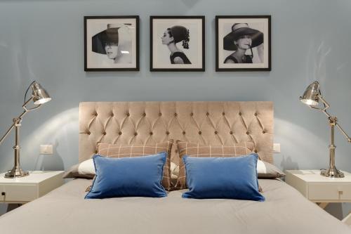 a bedroom with a bed with three pictures on the wall at Cozy Borgo in Florence