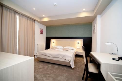 Hotel Nova في تارغوفيست: غرفة نوم بسرير ومكتب وسرير