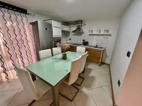 a dining room with a table and chairs and a kitchen at Apartma Sia Koper in Koper