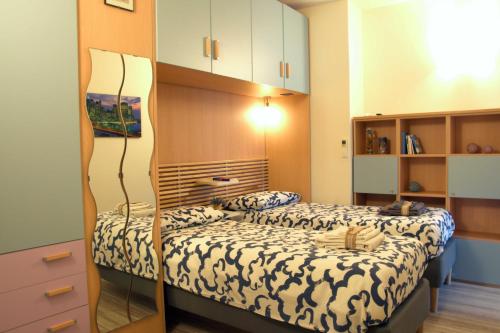 een kleine slaapkamer met een bed met een spiegel bij Una spettacolare vista mare - Casa con Jacuzzi in Bergeggi