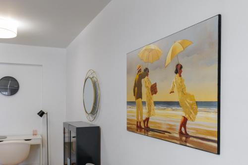 Faliro lux apartment by the sea vipgreece في أثينا: لوحة لأشخاص يمشون على الشاطئ مع مظلات