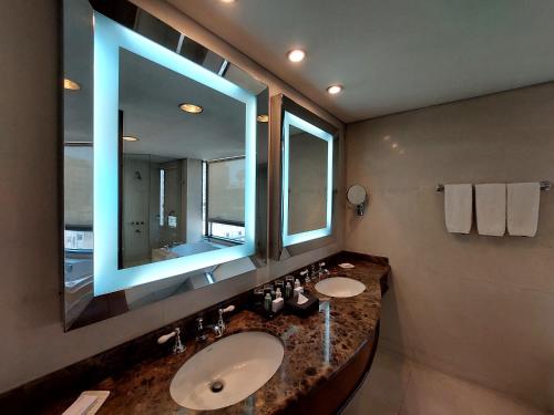 ein Badezimmer mit zwei Waschbecken und einem großen Spiegel in der Unterkunft Regal Pacific Puerto Madero in Buenos Aires