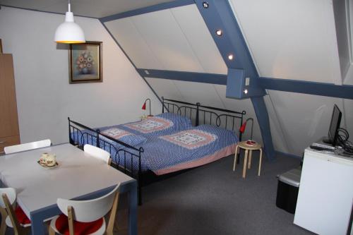 1 dormitorio con 1 cama, mesa y sillas en Appartement Hoeve Polsdonk, en Oirschot