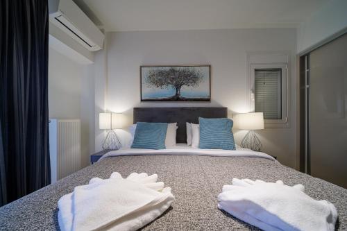 um quarto com uma cama com duas toalhas brancas em Faliro lux apartment by the sea vipgreece em Atenas