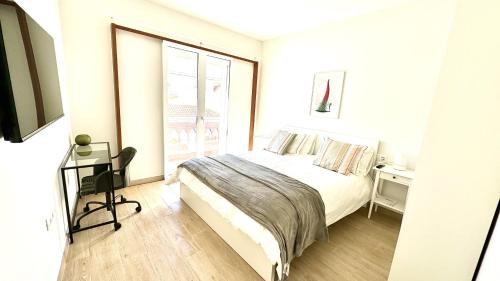 a white bedroom with a bed and a window at Suit Dreams Vilaflor by Deihu Experiences in Vilaflor