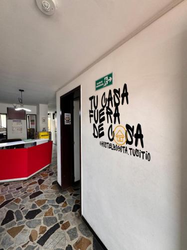una pared con escritura en un lateral de un edificio en Hostel Bogotá Normandia VIP, en Bogotá