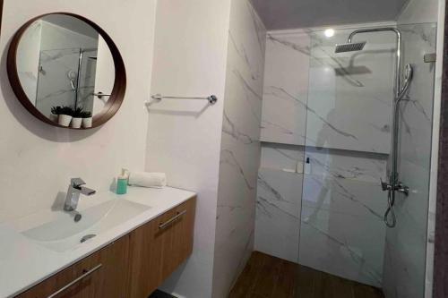 bagno con lavandino e doccia con specchio di Blue Coast Apartment - Vibe Dominicus a La Laguna