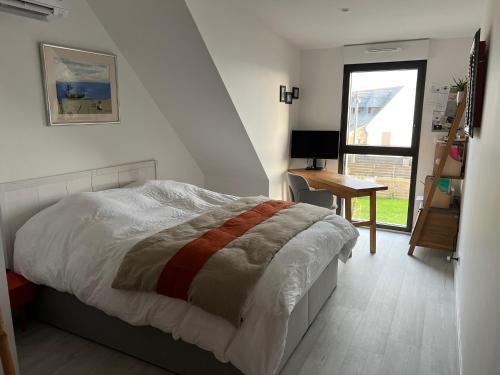 a bedroom with a bed and a desk and a window at Villa front de mer Carnac in Carnac