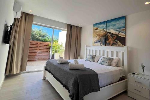 una camera con un grande letto e una grande finestra di Blue Coast Apartment - Vibe Dominicus a La Laguna