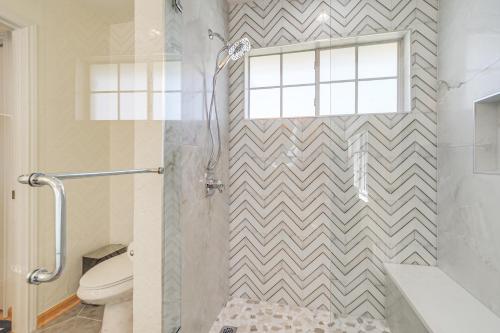 a bathroom with a shower and a toilet and a window at Pin Oak Farmhouse with Patio in Dripping Springs in Dripping Springs