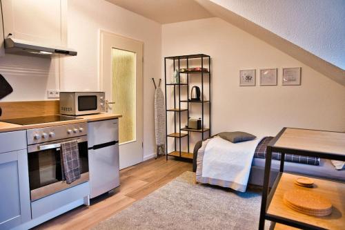 a kitchen with a stove and a room with a bed at Apartment im Herzen Bochums (1km zum Hauptbahnhof) in Bochum