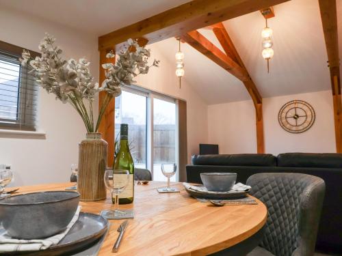 a dining room with a table with a bottle of wine at The Stables Merrydown in Axminster