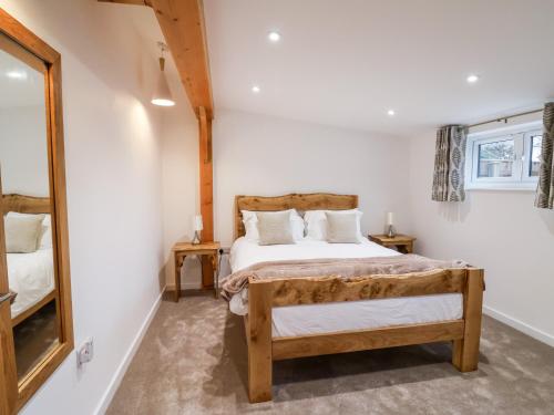 een slaapkamer met een bed en een spiegel bij The Stables Merrydown in Axminster