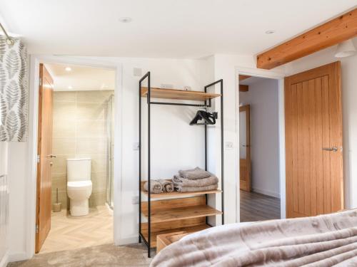 a bedroom with a walk in shower and a toilet at The Stables Merrydown in Axminster
