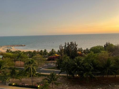 a view of a beach with palm trees and the ocean at Comfortable Family Apartment at Sealinks Mui Ne in Ấp Ngọc Hải