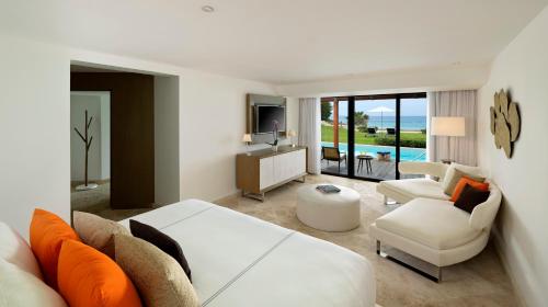 a living room with a bed and a couch and a tv at Paradisus Los Cabos - Adults Only - All Inclusive in Cabo San Lucas