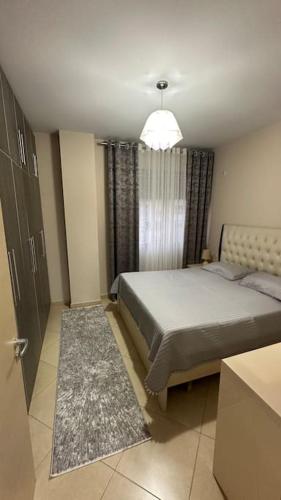 Tirana Apartments Onea's في تيرانا: غرفة نوم بسرير كبير ونافذة