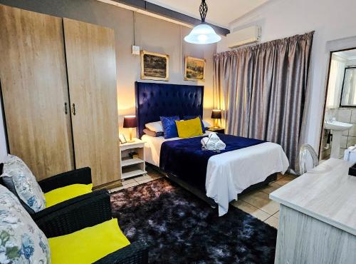 a bedroom with a bed and a chair in it at Leana Hub Guest House in Potchefstroom
