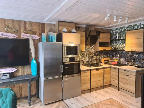 a kitchen with stainless steel refrigerator and wooden cabinets at Camping - Park Władysławowo in Władysławowo