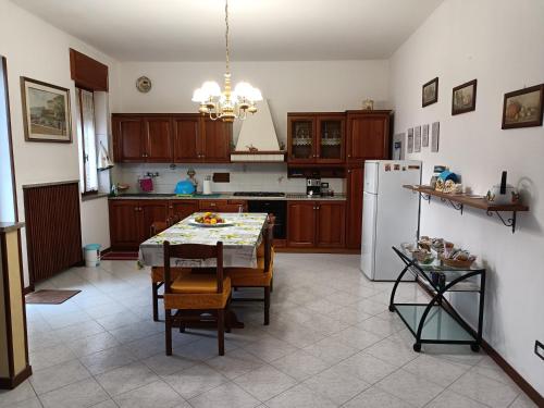 a kitchen with a table and a white refrigerator at Casa vacanza da Gina in Valeggio sul Mincio