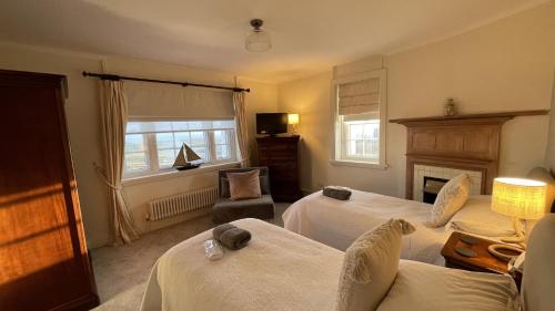 a hotel room with two beds and a fireplace at Tan Y Cytiau in Holyhead