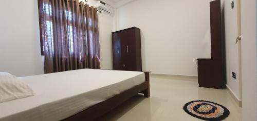 a bedroom with a bed and a window and a rug at King's Villa Appartement in Matara