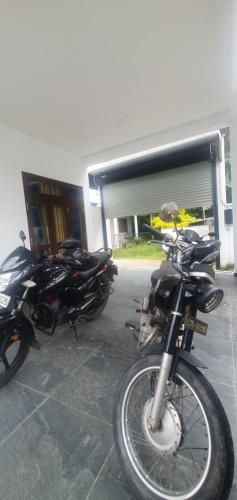 two motorcycles parked in front of a building at King's Villa Appartement in Matara