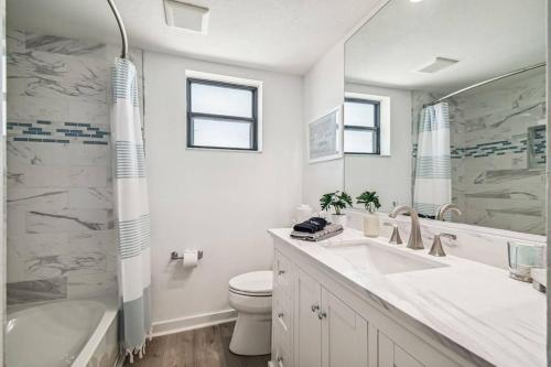 a bathroom with a sink and a toilet and a tub at Hernando Hideaway:Heated Pool/Decks/Dock/Balcony/Yard w/ Firepit/Kayaks in Hernando Beach